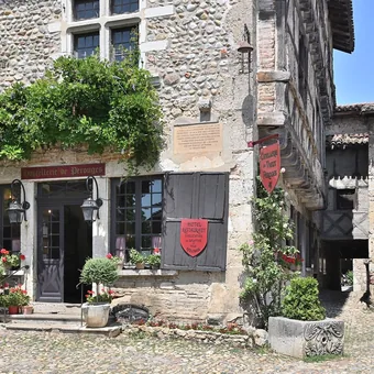 Maison à colombages et arcades dans une ruelle pavée de la cité médiévale de Pérouges