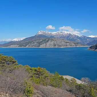 Lac de Serre-Ponçon devant des sommets encore enneigés