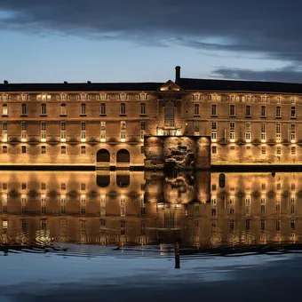 Façade de l'Hôtel-Dieu de Toulouse se reflétant dans la Garonne