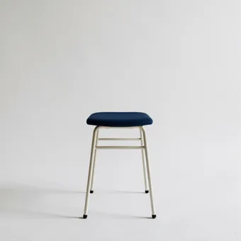 Tabouret devant un fond photographique blanc, studio vide