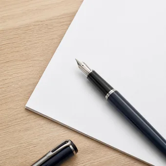 Stylo plume pose sur une feuille vierge