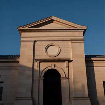 Facade d'hotel de ville en pierre claire, fronton nu et cadran vierge