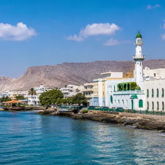 Mosquée et front de mer au pied des montagnes désertiques